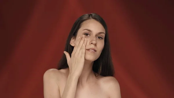Bir Kadın Temiz Pürüzsüz Nemlendirilmiş Yüz Derisine Dokunur Stüdyoda Kırmızı — Stok fotoğraf