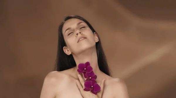 Una Mujer Con Flores Orquídea Sus Manos Toca Tórax Pecho —  Fotos de Stock
