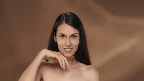 一个女人表现出她完美的皮肤和正常的面部特征 一个身披褐色背景的精液女子的画像 自然美 整形手术 护理的概念 — 图库照片