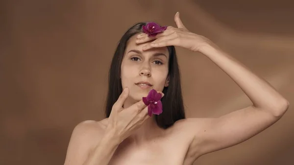 Una Donna Con Fiori Del Orchid Nelle Sue Mani Tocca — Foto Stock