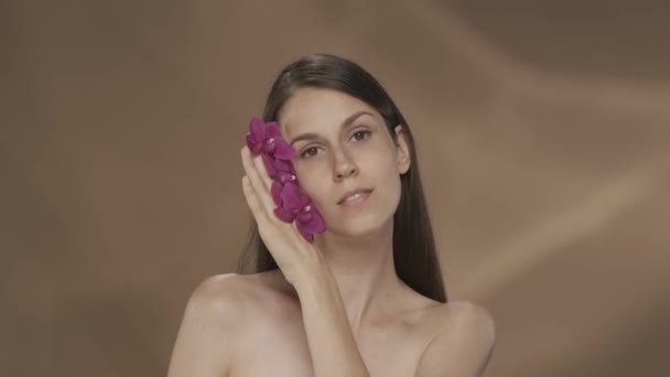 Una Donna Con Fiori Del Orchid Nelle Sue Mani Tocca — Video Stock