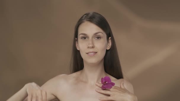 Kobieta Zamyka Oko Kwiatem Orchidei Portret Kobiety Studiu Brązowym Tle — Wideo stockowe