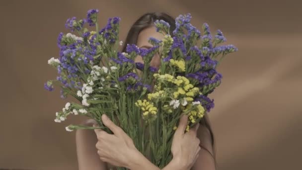 Uma Mulher Esconde Rosto Atrás Buquê Flores Silvestres Mulher Afasta — Vídeo de Stock