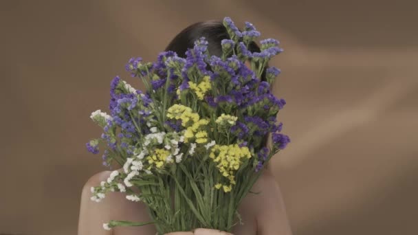 Kvinna Gömmer Sitt Ansikte Bakom Bukett Vilda Blommor Kvinnan Knuffar — Stockvideo