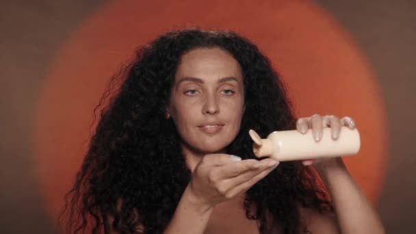 Μια Γυναίκα Κρατά Ένα Μπουκάλι Λοσιόν Κρέμα Απλώνει Στο Χέρι — Αρχείο Βίντεο