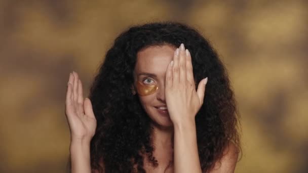 Жінка Відкриває Обличчя Видаляючи Долоні Які Покривали Жінка Золотими Плямами — стокове відео