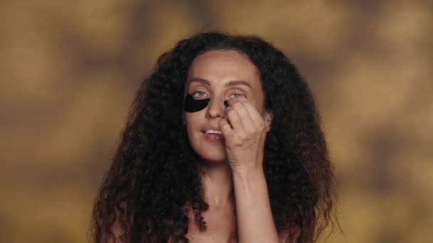 Bir Kadın Gözlerinin Altındaki Siyah Hidrojel Bantlarını Çıkarır Yüzüne Dokunarak — Stok video