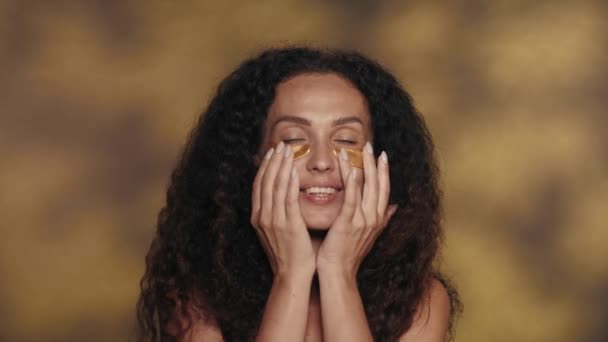 Жінка Розгладжує Золоті Плями Під Очима Вирівнює Волосся Дме Поцілунок — стокове відео
