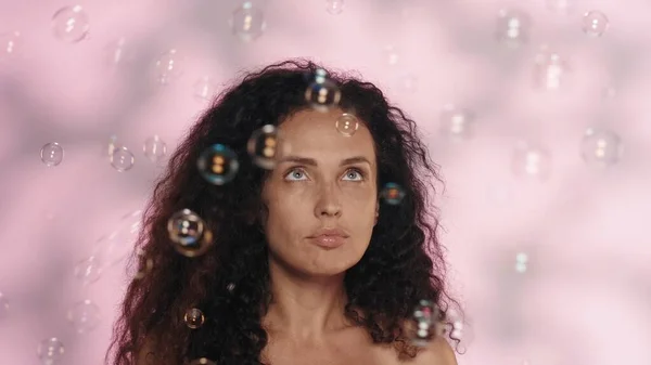 ピンクのバックグラウンドでスタジオでセミナーの女性の肖像画が閉じられました 石鹸の泡に囲まれた女性 化粧品 スキンケア 女性の健康の概念 — ストック写真