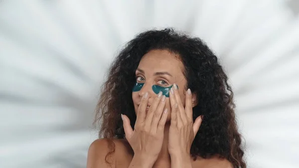 女性が修正し 目の下の青いヒドロゲルパッチを滑らかにします ハイライトのあるグレーの背景にあるスタジオのセミノードの女性 化粧品 スキンケア — ストック写真
