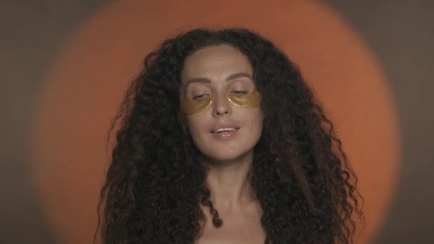 Długowłosy Kręcone Brunetka Wykonuje Zabiegi Kosmetyczne Portret Kobiety Seminarium Złotymi — Wideo stockowe