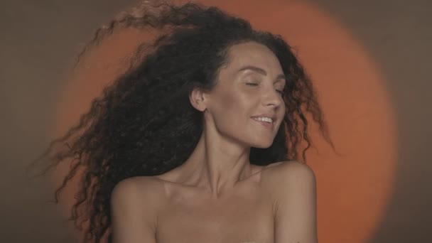 Seminude Frau Auf Orangefarbenem Hintergrund Mit Kreisförmigem Licht Dicke Lange — Stockvideo