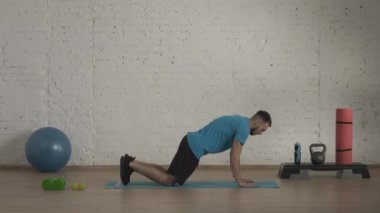 Atletik erkek fitness koçu çevrimiçi dersler için ev stüdyosunda egzersiz yapıyor. Spor kıyafetli bir adam klasik şınav egzersizi yapıyor. Sağlık sigortası konsepti. HDR BT2020 HLG Malzemesi.