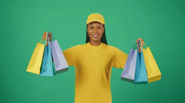 Retrato Una Repartidora Con Gorra Camiseta Amarilla Sosteniendo Muchas Bolsas —  Fotos de Stock