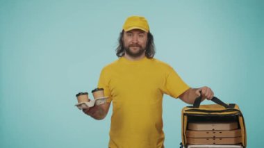 Kurye hizmeti konsepti. Sarı şapkalı bir teslimatçının portresi. Elinde taşınabilir pizza kutuları ve kahve tutacağı olan bir sırt çantası var. Yemek servisi ürünleri. Mavi arkaplanda izole.