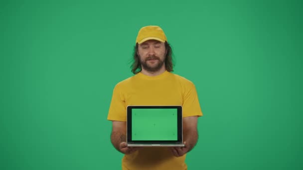 Sarı Şapkalı Tişörtlü Bir Teslimatçının Portresi Elinde Dizüstü Bilgisayarla Kameraya — Stok video