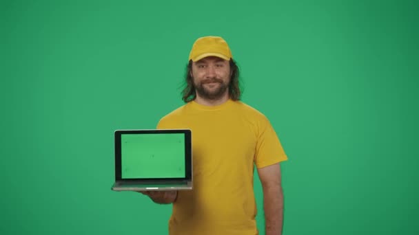 Portret Kuriera Żółtej Czapce Koszulce Laptopem Kartą Kredytową Patrzącego Kamerę — Wideo stockowe