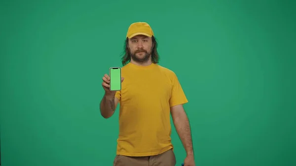 Potret Seorang Pria Pengiriman Topi Kuning Dan Kaos Memegang Smartphone — Stok Foto