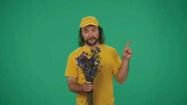 Retrato Homem Entrega Boné Amarelo Tshirt Segurando Flores Apontando Para — Fotografia de Stock