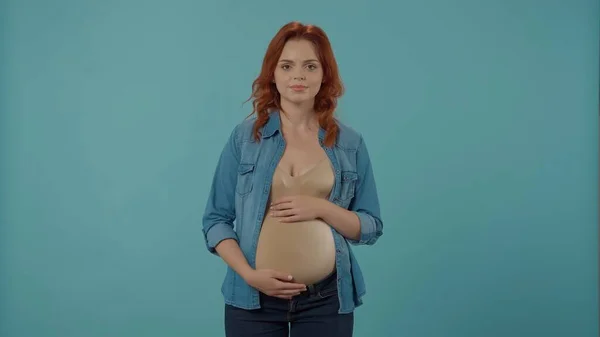 一个年轻的孕妇用手抱着她的大肚子的画像 被蓝色隔离的孕妇 母性和爱情的概念 — 图库照片