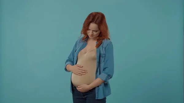 若い妊娠中の女性の肖像画は 彼女の手で彼女の大きな腹を抱擁しています 妊娠中の女性はブルーで孤立しました そして愛の概念 — ストック写真
