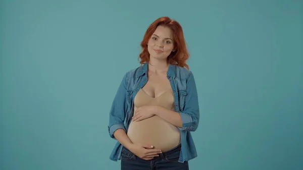 若い妊娠中の女性の肖像画は 彼女の手で彼女の大きな腹を抱擁しています 妊娠中の女性はブルーで孤立しました そして愛の概念 — ストック写真