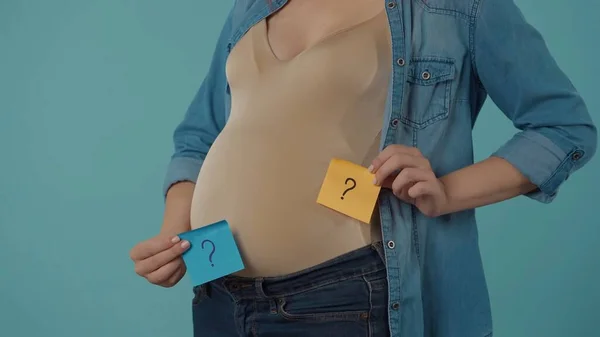 Hamile Bir Kadın Göbeğinde Soru Işaretleri Olan Kare Kağıtlar Tutuyor — Stok fotoğraf