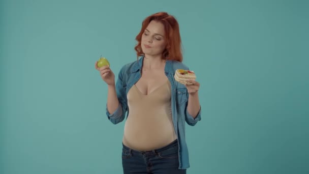 Gravid Kvinna Väljer Mellan Hälsosam Och Ohälsosam Mat Tårta Och — Stockvideo