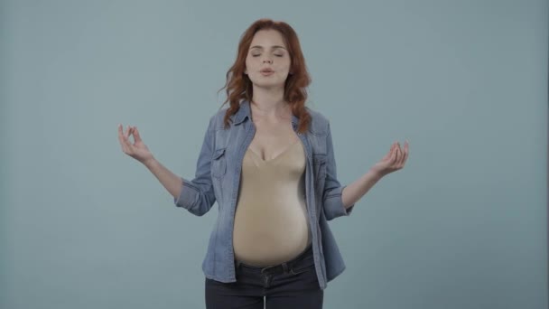 Rothaarige Schwangere Meditiert Studio Auf Blauem Hintergrund Großaufnahme Die Frau — Stockvideo