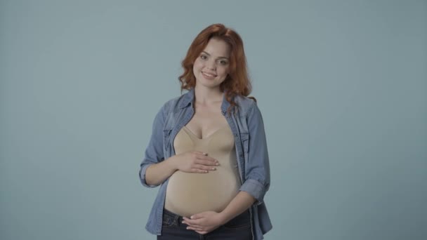 孕妇可以得到一盘沙拉或一块蛋糕 一个女人选择甜食是她的选择 一个蓝色背景的女人在工作室里对怀孕的渴望 — 图库视频影像