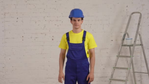 Średni Film Młodym Pracownikiem Budowlanym Stojącym Remontowanym Pokoju Pokazujący Wiadro — Wideo stockowe