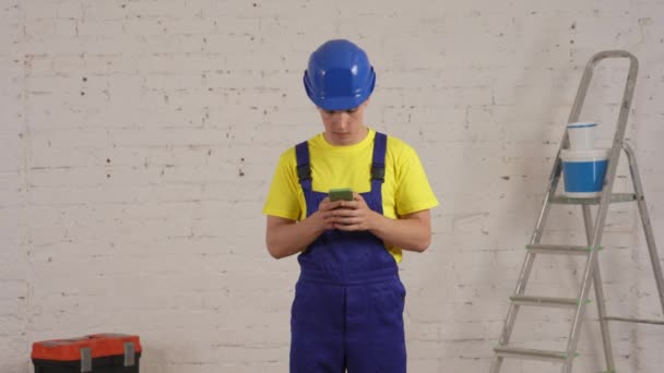 Vídeo Médio Trabalhador Construção Sala Segurando Smartphone Digitando Pesquisando Navegando — Vídeo de Stock