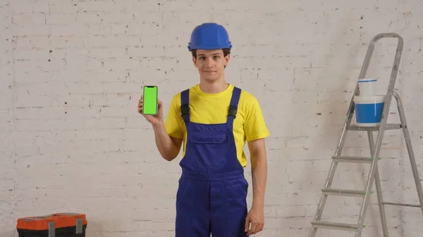 Střední Záběr Mladého Stavebního Dělníka Stojícího Místnosti Držícího Smartphone Reklamním — Stock fotografie