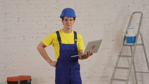 Medium Shot Young Construction Worker Standing Room Holding Laptop Researching — Stock Photo, Image