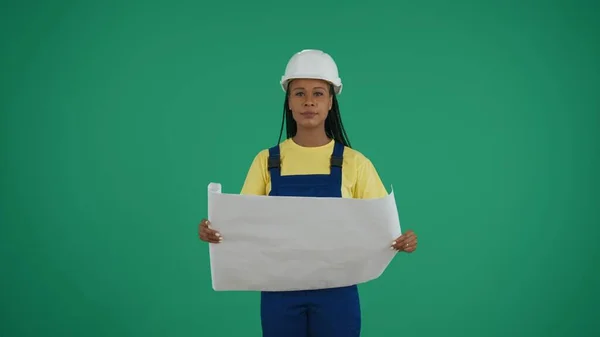 中緑色のスクリーンは 彼女の計画を周囲と比較して研究し ダークスキンの若い女性建設労働者のクロマキーショットを隔離しました 修理広告について 信頼性について — ストック写真