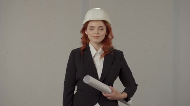 건축가는 엄지손가락을 조심스럽게 보여줍니다 배경에 스튜디오에서 그녀의 청사진 헬멧에 여자의 — 비디오