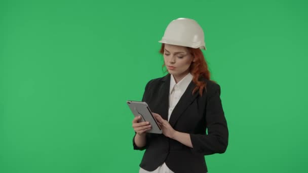 건축가는 물체의 검사를 수행하고 태블릿에 메모를합니다 헬멧에 비즈니스 여자와 스튜디오에서 — 비디오