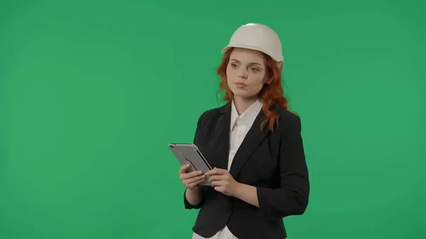 一位戴着防护头盔的女建筑师 工作室里的绿色屏幕背景上有一块石碑 广告区 模拟工作区 — 图库照片