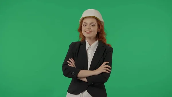 女建筑师戴着防护头盔 穿着严格的西服 在工作室的绿屏背景下 建筑项目 广告区 模拟工作区 — 图库照片