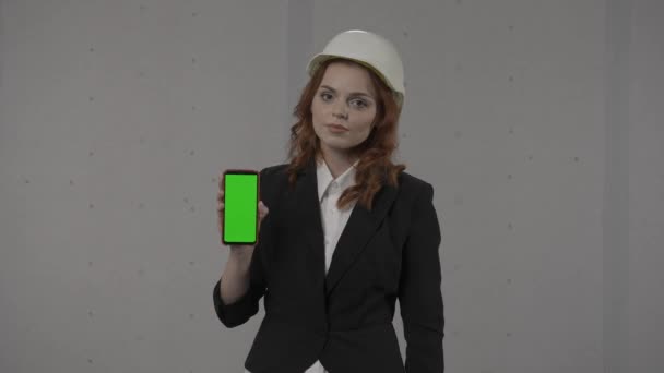 Eine Architektin Hält Den Smartphone Bildschirm Nach Vorne Zeigt Auf — Stockvideo
