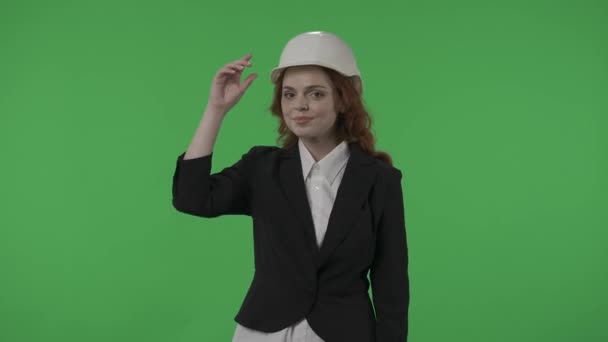 그녀의 건축가는 그녀의 가슴에 똑바로 앞으로 보인다 배경에 스튜디오에서 헬멧에 — 비디오