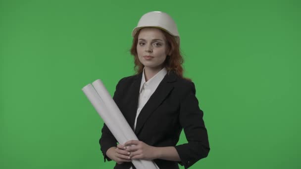 그녀의 청사진이있는 건축가의 초상화 닫습니다 배경에 스튜디오에서 헬멧과 엄격한 정장에 — 비디오