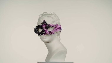 Karnaval maskeli güzel antik tanrıça Venüs mermer heykelinin yakın çekimi. Roma dönemi kadın portresi platfolm üzerinde büstü. Beyaz arka planda izole edilmiş. Yaratıcı soyut kavram.