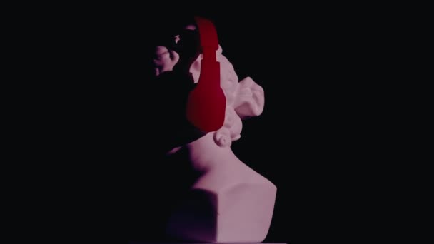 ヘッドフォンの美しい古代の女神金星大理石像のクローズアップショット プラットフォーム上で回転するロマン時代の女性バストの肖像画 ブラックバックで孤立 クリエイティブな抽象概念 — ストック動画