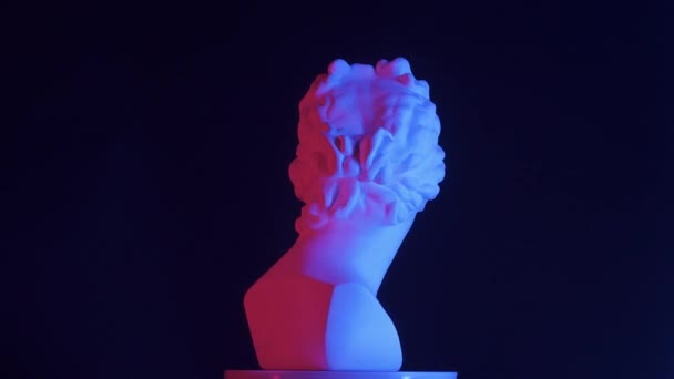 赤と青のネオンライトの美しい古代の女神金星大理石像のクローズアップショット プラットフォーム上で回転するロマン時代の女性バストの肖像画 ブラックバックで孤立 クリエイティブアブストラクト — ストック動画
