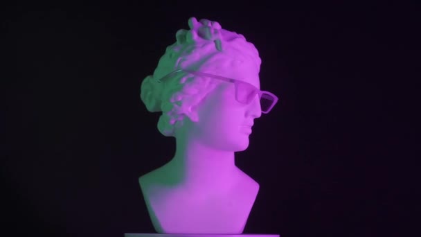 紫色の光のガラスで古代の女神金星大理石像のクローズアップショット プラットフォーム上で回転するロマン時代の女性バストの肖像画 ブラックバックで孤立 創造的な抽象概念 Hdrについて — ストック動画