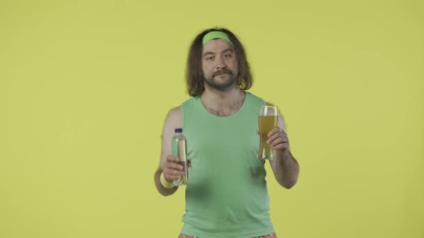 Pria Dalam Pakaian Olahraga Memegang Botol Air Dan Segelas Bir — Stok Video