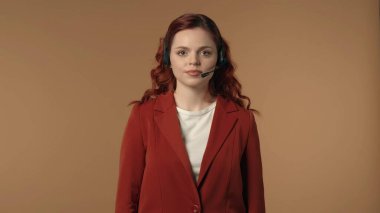 Çağrı merkezi kulaklığı takmış mutlu ve rahat genç bir kadının kameraya bakarken orta izole edilmiş görüntüsü. Kadın sakin ve huzurlu görünüyor. İş ve çağrı merkezleri, ajanslar için reklam.