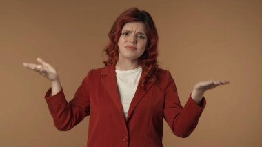 Kızgın ve tatminsiz genç bir kadının, sanki biriyle tartışıyor ve vücut dilini kullanıyor gibi, duygusal olarak kameraya bakarken orta derecede izole edilmiş görüntüsü. Yaratıcı içerik veya reklam.