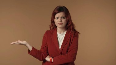 Öfkeli ve tatminsiz genç bir kadının, duygularını ifade etmek için vücut dilini kullanarak kameraya duygusal olarak baktığı orta derece izole edilmiş bir fotoğraf. Yaratıcı içerik veya reklam.